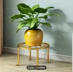 Modern circular Metal Plant Stand Pakistan with wood shelf holding an orange flower pot stand.